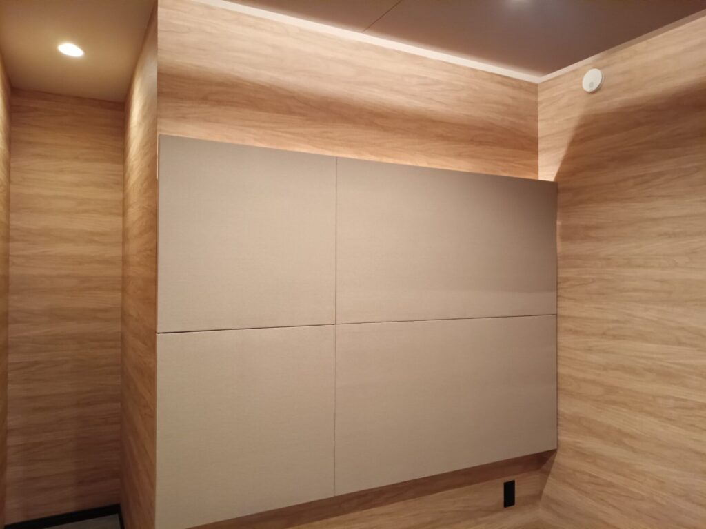壁面吸音パネルの設置された写真、壁は木目柄