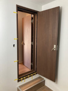 1か所の出入口に2セットの木製防音ドアを設置し扉を開いている写真