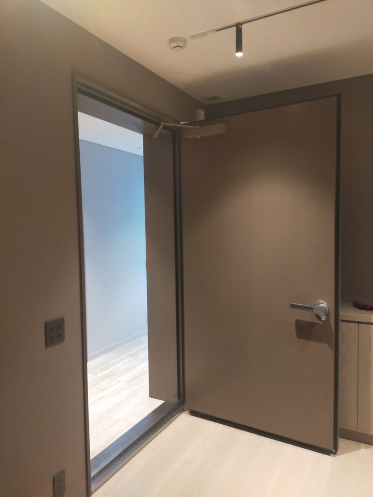 D45の鋼製防音ドアを採用。通常はドア幅が900㎜ですが、今回は幅が1200㎜のドアに。200kgの重みがあるため、4人掛かりで取り付けた。高さも2300㎜、大型の片開き防音ドア。