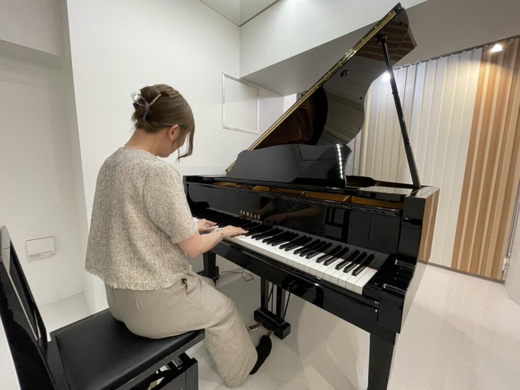 ショールーム防音室でグランドピアノの響きを確かめる様子
