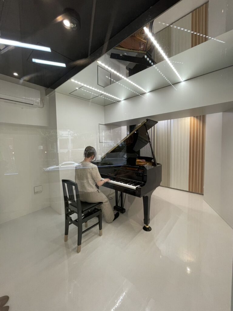 防音FIX窓越しに見たショールーム防音室内のピアノ演奏